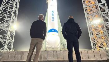 Two men looking at New Glenn rocket on pad