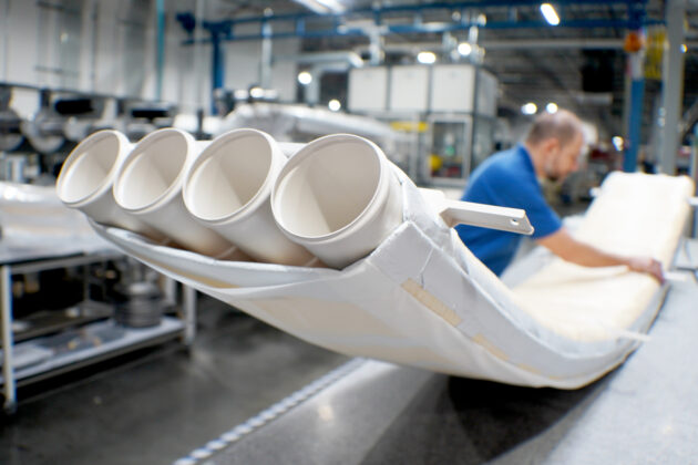 Worker inspects thermoplastic tubing for airduct assembly